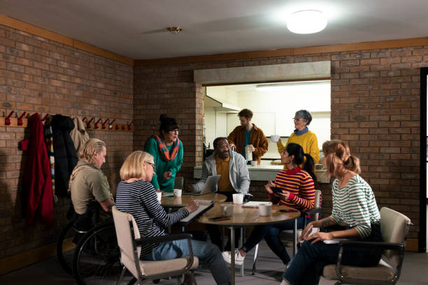 Making Notes at a Community Meeting Group of volunteers hosting a meeting about their community in the North East of England. They are a diverse group and are all talking together, organising community events. neighborhood crime watch stock pictures, royalty-free photos & images