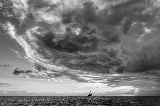istock Sunset Sailboat Storm Looming Ocean Clouds Black And White 1408433636