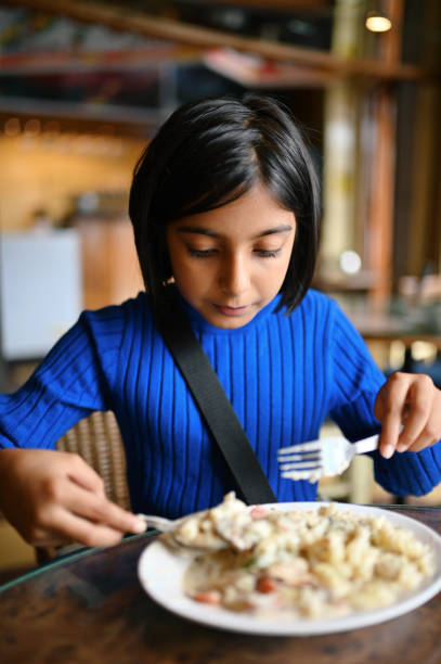 istock Girl eating in a restaurant 1408434737