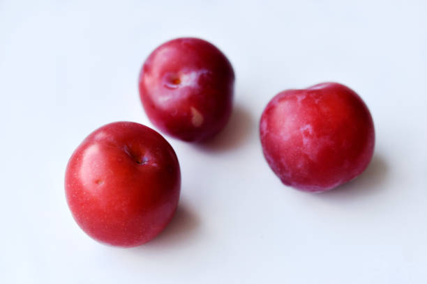 istock Juicy fresh red plums on a white background 1408437121