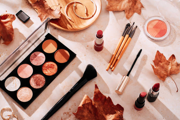 Autumn skincare and autumn makeup concept with beauty products on table Beauty products and makeup, autumn leaves on beige background. Autumn skincare and autumn makeup concept. makeup stock pictures, royalty-free photos & images