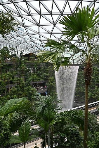 Changi, Singapore - July 13, 2022: The world's tallest indoor waterfall within Jewel of Terminal 1 Changi airport. Made of rain vortex spanning over 7 storeys high
