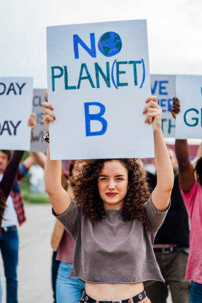 「惑星なしb」の看板を掲げた若い女性 - protest women marching street ストックフォトと画像
