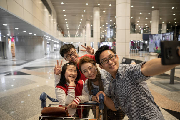 selfie familiar chino asiático en el aeropuerto mientras espera el embarque - two parent family technology mobility men fotografías e imágenes de stock