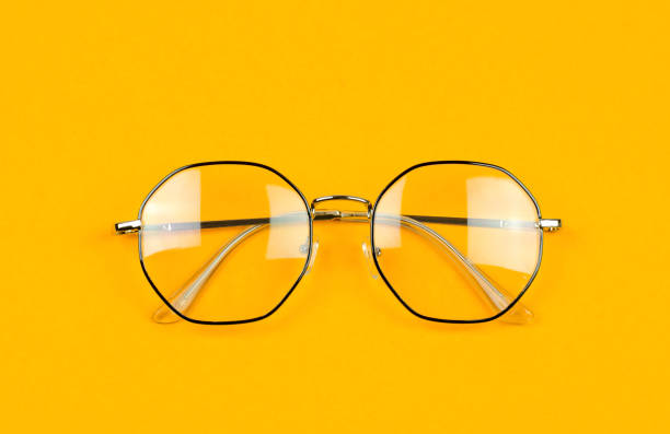 istock Stylish glasses in an iron black frame on an orange background 1408447493