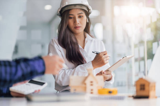 istock Female architect designers in the office work with contractor engineers modeling houses and writing housing projects. 1408448974