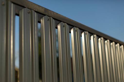 Steel fence. Fence is silver in color. Steel obstacle. Fenced area.