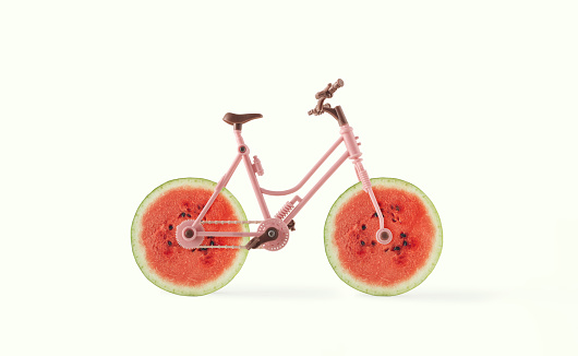 A bicycle with wheels made of watermelon slices on isolated pastel white background. Minimal abstract summer fruit scene. Raw food concept. Creative idea of healthy, organic, vegetarian food delivery.