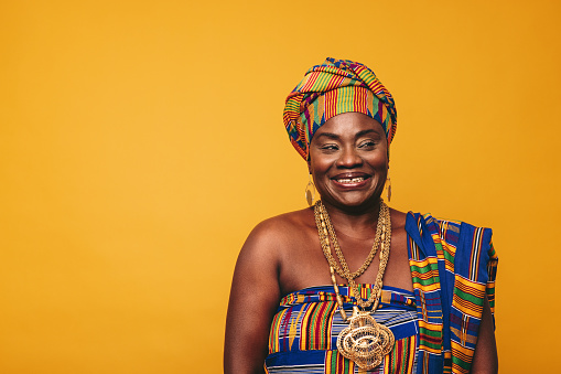 Mujer ghanesa sonriente con ropa tradicional elegante en un estudio photo
