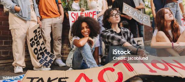 Cheerful Teenage Girl Sitting With A Group Of Youth Peace Activists Stock Photo - Download Image Now