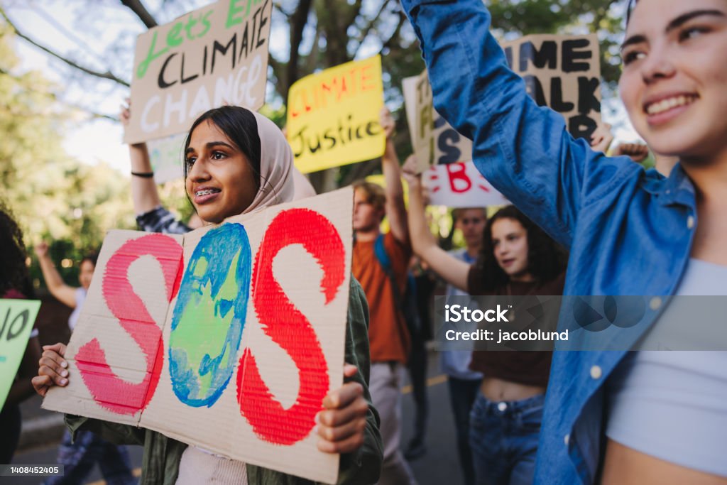 Save our species campaign Save our species campaign. Group of multicultural youth activists carrying posters while marching against global warming and climate change. Diverse young people joining the global climate strike. Climate Justice Stock Photo