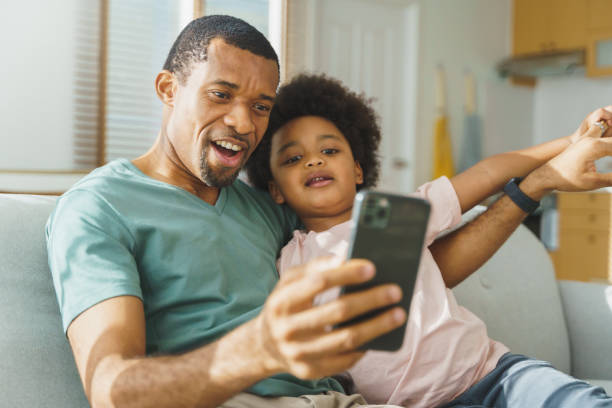 istock African father and his boy using phone 1408455326