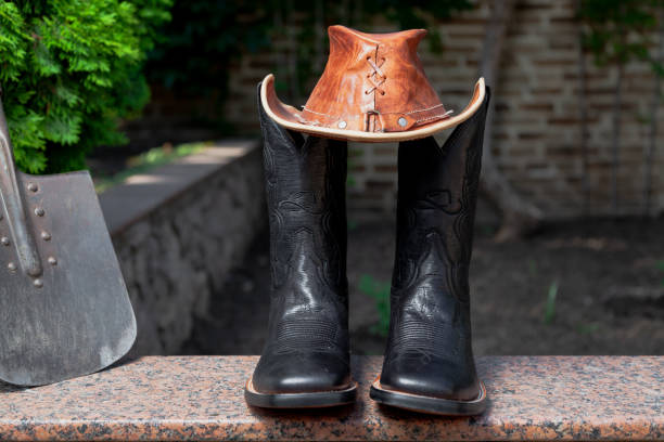 istock Cowboy hat and boots with shovel in garden 1408455454