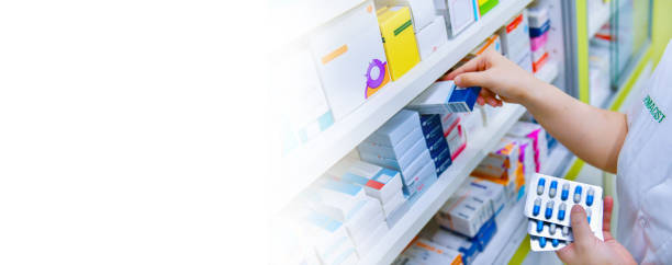 farmacéutico sosteniendo la caja de medicamentos y el paquete de cápsulas en la farmacia de farmacia - pharmacy medicine pharmacist storage room fotografías e imágenes de stock