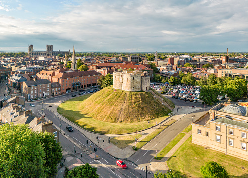 York, UK. 1 July 2022. Aerial view over the skyline and Clifford's Tower in York, England at sunset. With York Cathedral in background.