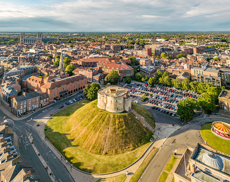 York, UK. 1 July 2022. Aerial view over the skyline and Clifford's Tower in York, England at sunset. With York Cathedral in background.