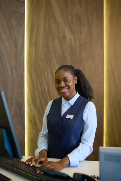istock Young receptionist entering personal data of guests into database by counter 1408468583