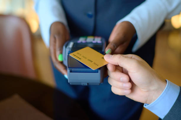 istock Manager holding payment terminal while man with credit card paying for purchase 1408468627