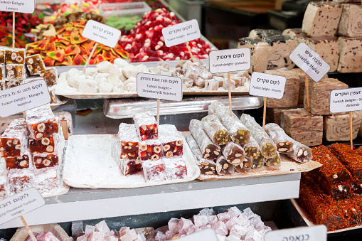 Turkish delight sweets filled with almonds, strawberry, and hazelnut with halvah and candy on display at Carmel Market, Tel Aviv