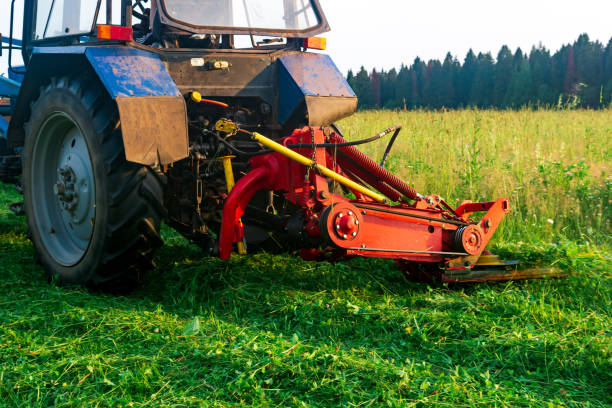 Cutting grass with a riding mower in a large city park.