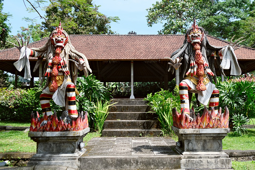 Statues guarding the temple at the magnificent Tirta Gangga, a former royal palace in eastern Bali, Indonesia. Named after the sacred river Ganges in Hinduism, it is noted for the water palace, bathing pools and its Patirthan temple.\nIndonesia