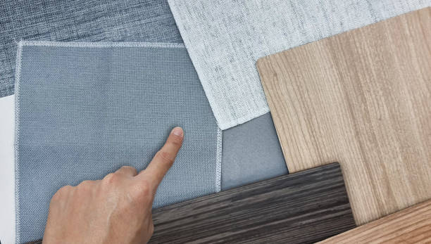 istock architect's hand choosing interior material samples for japanese minimal style contains oak laminated, walnut veneer, grey linen drapery. combination of material samples for schematic design. 1408476164