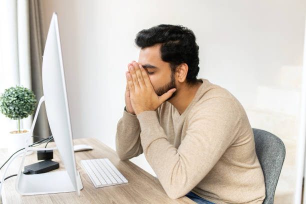 istock Tired businessman frown while checking financial documents, touching forehead with the arm, sitting in the trendy office at the laptop, consulting client online, analyze statistic 1408477300