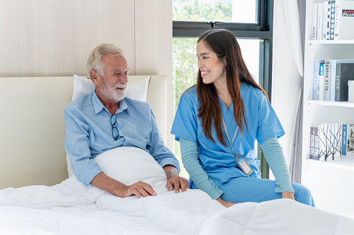 Medical staff taking and caregiver senior man in Home. Home care concept.