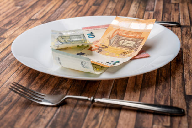 billetes de euro tirados en un plato con cubiertos - dinner currency table business fotografías e imágenes de stock