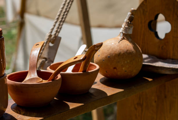 medieval reenactment - clay bowls with wooden spoons placed on a shelf