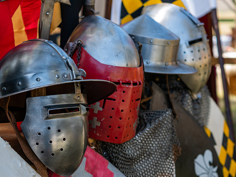 medieval historical reenactment - display of various types of medieval plate armor helmets or lighter metal helmets
