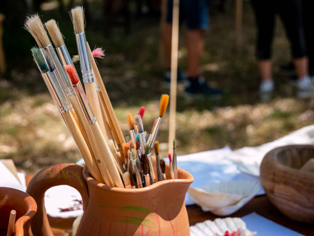 istock paint brushes in a ceramic jug, medieval painter's equipment on a table 1408485648