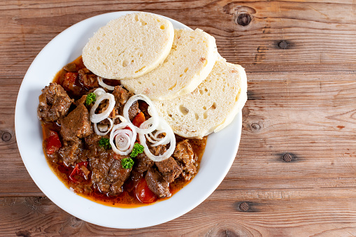 Fine Meat - Beef Goulash in a with Red Pepper on wooden table. Top view. Copy space
