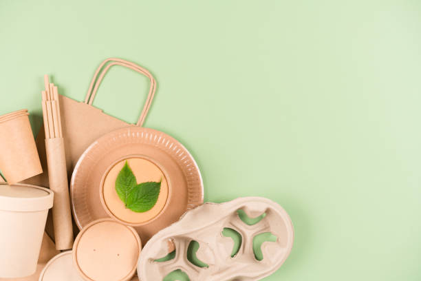 istock Eco paper utensils and disposable tableware set, food containers and paper cups over light green background with copy space. Sustainable food packaging concept 1408494429