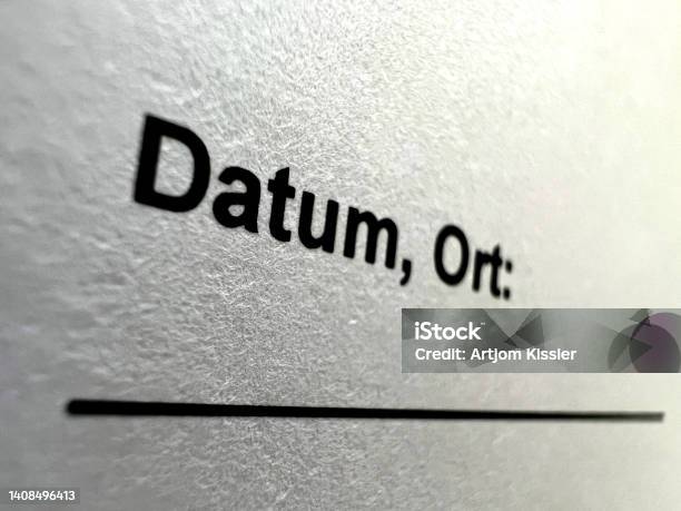 A Macro Image Of White Paper With The Imprint Date Place In German Stock Photo - Download Image Now