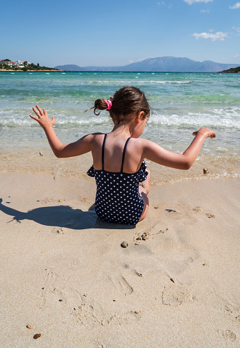 Beautiful little girl playing in the sea
