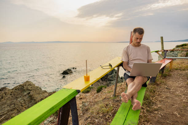 istock Modern young man working on laptop, during his summer vacation 1408497849