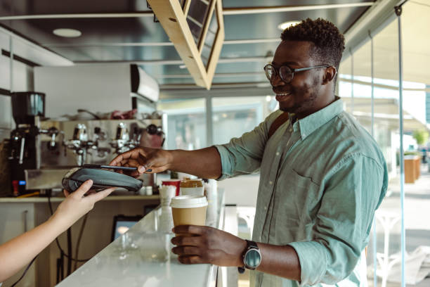 istock An African American young man paying for coffee in cafeteria 1408504964