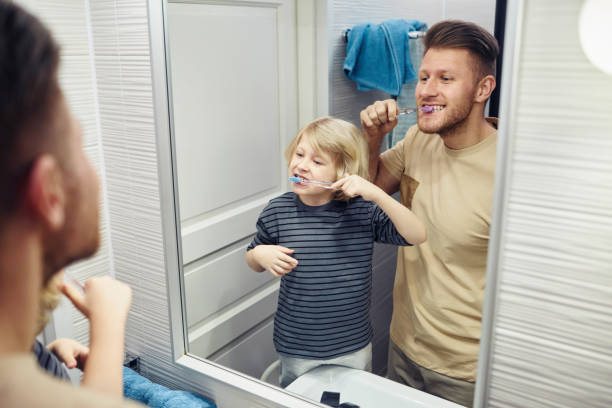 istock Little Boy Brushing Teeth with Dad 1408510226