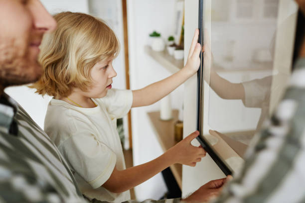 istock Father and Son Hanging Picture Together 1408510251
