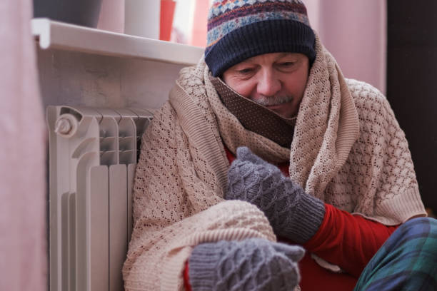 homme se sentant froid à la maison avec des problèmes de chauffage à la maison - grelotter photos et images de collection