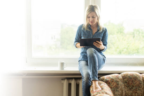 istock Attractive businesswoman using a digital tablet in front of windows 1408512168