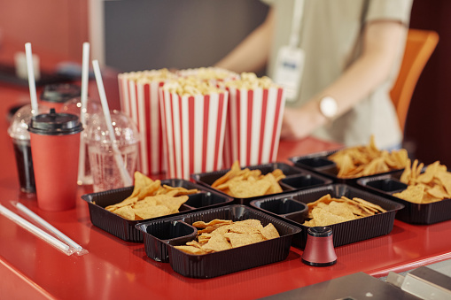 Close-up f popcorn, chips and soda on counter selling for spectators in cinema
