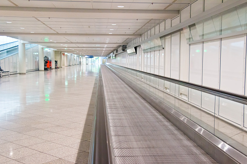 Empty moving sidewalk or also called a flat escalator at an airport departure area.
This image is part of a series,