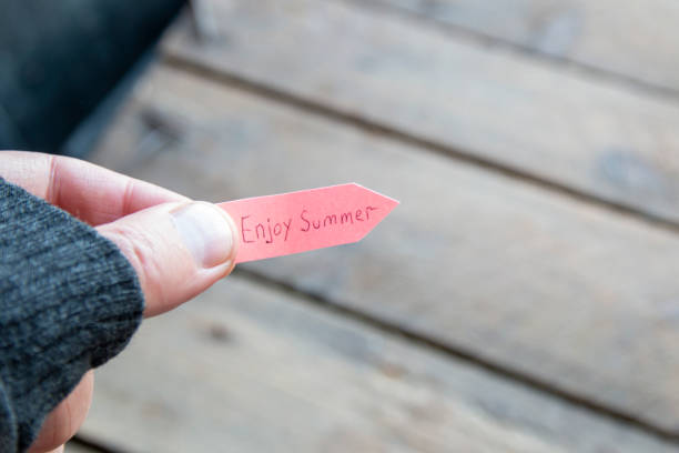istock Enjoy summer concept. A man holds a pointer with an inscription. 1408516199