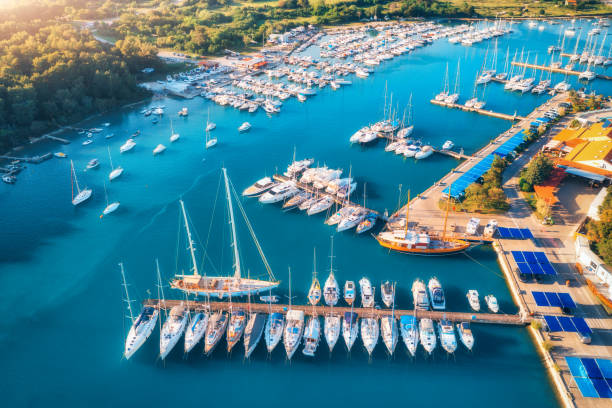 vista aérea de barcos y yates de lujo en el muelle al atardecer en verano en pula, croacia. paisaje colorido con veleros y lanchas a motor en la bahía del mar, jatty, mar azul claro. vista superior del puerto. viajar - morning croatia blue sea fotografías e imágenes de stock