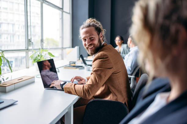 istock Happy Business Man Working In The Office With Unrecognizable Colleagues 1408517163
