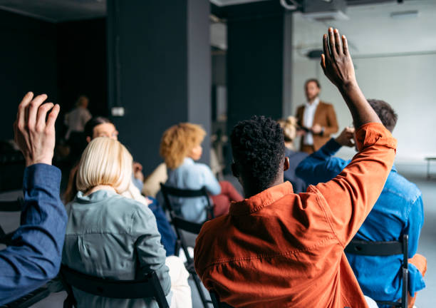 Business Peoples Volunteers To Answer A Question During A Seminar Unrecognizable group of multi-ethnic businesspeople raising their hands during a presentation at their company. q and a stock pictures, royalty-free photos & images