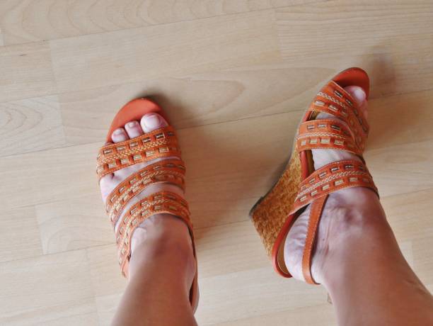 istock Orange sandal on the ladies' foot 1408522786