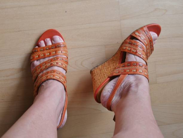 istock Orange sandals on the women's foot 1408522806